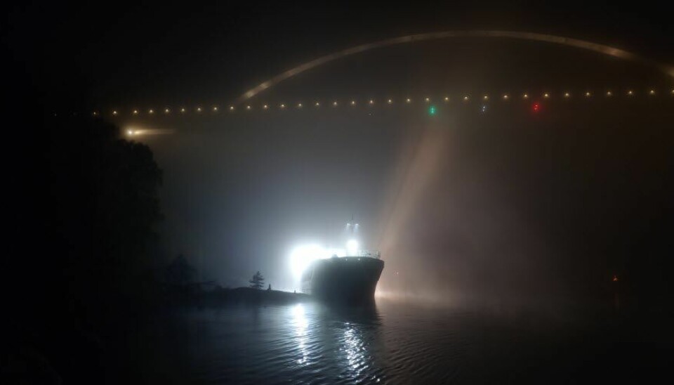 BOM FAST: Et stort skip står fast under Svinesundsbrua torsdag morgen. Bildet viser et norsk skip som står fast under Svinesundsbrua. Foto: Kustbevakningen / Handout / NTB