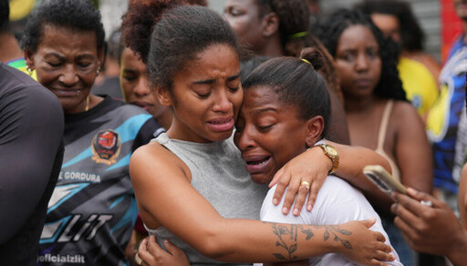 SØRGER: Mennesker som bor i Rio de Janeiro sørger over alle de døde. Årsaken er en stor aksjon utført av politiet. Bildet viser to damer som klemmer og gråter. Foto: Silvia Izquierdo / AP / NTB