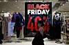 En vindu inn til en klesbutikk med mannekenger med kær på seg. Forbi går en person. Innenfor står det et stort skilt hvor det står Black Friday 40% Off.