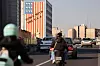 Bildet viser trafikken i Teheran i Iran. På en bygning henger det kritikk mot USA. Foto: Majid Asgaripour / Reuters / NTB