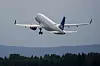 SAS-passasjerfly tar av fra rullebanen ved en skogkledd flyplass.