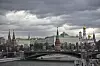 Kreml og Bolshoj Kamenny-broen over elven i Moskva under mørke skyer.