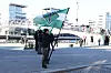 Medlemmer av Den nordiske motstandsbevegelsen holder grønne faner på torget i Fredrikstad.
