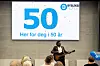 Artist Chand opptrer foran storskjerm med Dysleksi Norges 50-årsjubileum.