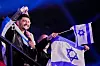Den israelske artisten Noam Bettan er omringet av israelske flagg i semifinalen av Eurovision i Wien.