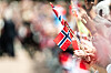 Mennesker på Slottsplassen i Oslo vifter med norske flagg under 17. mai-feiringen.