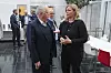 Kjersti Stenseng og Jan Davidsen står og snakker i et moderne møterom med andre personer bak.