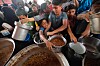 Folk får mat fra store kjeler ved et veldedig kjøkken i Nuseirat i Gaza.