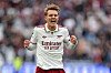 Martin Ødegaard i hvit Arsenal-drakt feirer med knyttede never på banen.