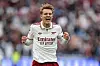 Martin Ødegaard i hvit Arsenal-drakt feirer med knyttede never på banen.