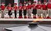 Barn i røde T-skjorter og bereter står på rekke og hilser ved Den evige flamme i Moskva.