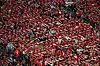 Tette tribuner fylt av norske supportere som gjør ro-bevegelsen med røde og hvite skjerf.