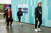 To norske fotballspillere går inn mot en turkis vegg med VM-tekst før kamp i New Jersey.