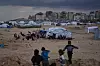 Bildet viser Gaza og barn som leker i framgrunnen. Foto: Abdel Kareem Hana / AP / NTB