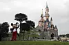 Bildet viser slottet i Disneyland Paris og Mikke Mus i framgrunnen. Foto: Francois Mori / AP / NTB