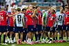Norske fotballspillere i røde drakter samles og applauderer på banen etter kampen.