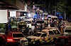 Ambulanser og politibiler står tett ved et brannsted i Bangkok om natten.
