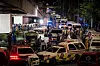 Ambulanser og politibiler står tett ved et brannsted i Bangkok om natten.