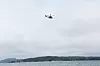 Bildet viser et helikopter over sjøen, der et skip kolliderte med en fritidsbåt. Foto: Björn Larsson Rosvall / TT / NTB