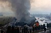 Tett røyk stiger opp fra en brann over bebyggelse i Kyiv etter nattlige angrep.