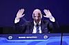 Gianni Infantino står bak en FIFA-talerstol og løfter begge hendene under kongressen i Luque.