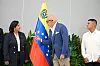 Dinorah Figuera og Jorge Rodríguez står foran det venezuelanske flagget under et offisielt møte i Caracas.
