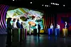 Partilederdebatt på en TV-scene med flere talere og stort skjermbilde i bakgrunnen.