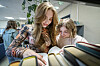 To skoleelever står ved en hylle på biblioteket og leser bøker.