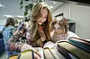 To skoleelever står ved en hylle på biblioteket og leser bøker.