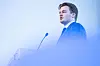 Lars Mikael Barstad Løvold står ved talerstol og mikrofon under FpUs landsmøte i Oslo.