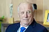 Kong Harald sitter i et kontorrom med lyse treflater og blå dress.