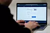 Person skriver på en bærbar pc med ID-porten åpnet på skjermen.