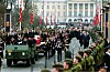 Bisettelsesprosesjon i Karl Johans gate med militært kjøretøy, båre og flagg.