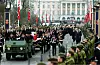 Bisettelsesprosesjon i Karl Johans gate med militært kjøretøy, båre og flagg.