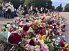 Bildet viser blomsterhav og folk som klemmer hverandre. Foto: Karin Flølo