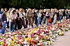 Bilde av mennesker som har møtt opp utenfor Slottet hvor de legger ned blomster for kong Harald. Foto: Lise Åserud / NTB