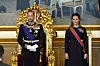 Kong Haakon står foran en gulltrone i Stortinget mens kronprinsesse Ingrid Alexandra står ved siden av.