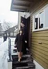 Kronprinsesse Sonja og kronprins Harald går ned en trapp fra familien til Sonja sitt hus om vinteren.
