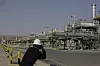 Fotograf tar bilder foran industrielle anlegg ved Khurais-oljefeltet i Saudi-Arabia.