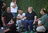 Pårørende sitter samlet på stoler og venter utenfor Kyrenia havn etter en båtulykke.