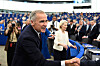 Mark Carney og Ursula von der Leyen står foran publikum i en sal med blå seter og kameraer.