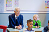 Statsminister Jonas Gahr Støre sitter ved en skolepult sammen med elever i et klasserom.