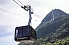 En gondolbane fører en kabin over Åndalsnes med bratt fjellandskap bak.