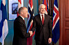 Jonas Gahr Støre og Mark Carney håndhilser foran norske og canadiske flagg i Oslo.