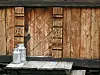 Bilde av to melkespann på trappa av et gammel hus på Sota sæter. Foto: Solveig Vikene / NTB
