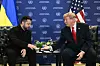 Donald Trump og Volodymyr Zelenskyj sitter og håndhilser foran FN-bakgrunn i New York.