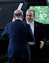 Iraks og Irans utenriksministre hilser foran en bil ved inngangen til Utenriksdepartementet i بغداد.