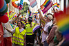 Pride-parade i Oslo med politiet synlig, regnbueflagg og deltakere langs gaten.