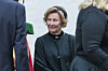 Dronning Sonja står foran et norsk flagg under gravferden fra Ris kirke i Oslo.