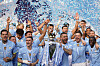 Manchester City-spillere jubler med Premier League-troféet mens blå konfetti fyller luften.